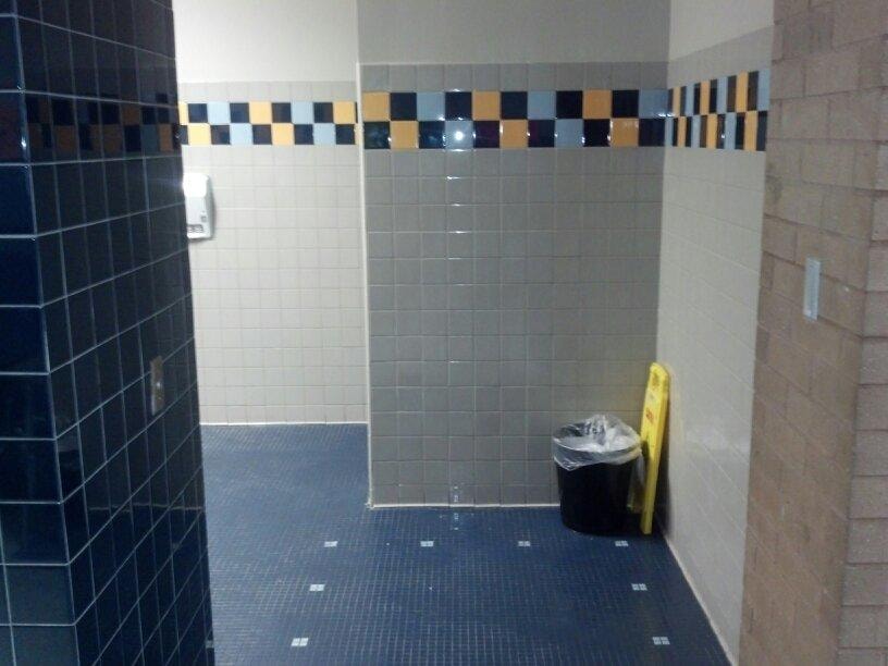 Completed tiled restroom corridor with decorative tile band