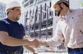 Construction professionals shaking hands at a job site